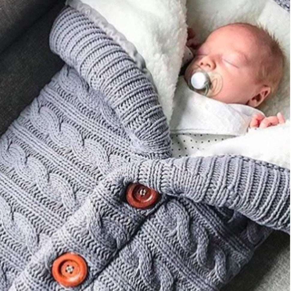 Bébé dormant paisiblement dans nid d'ange effet tricot gris