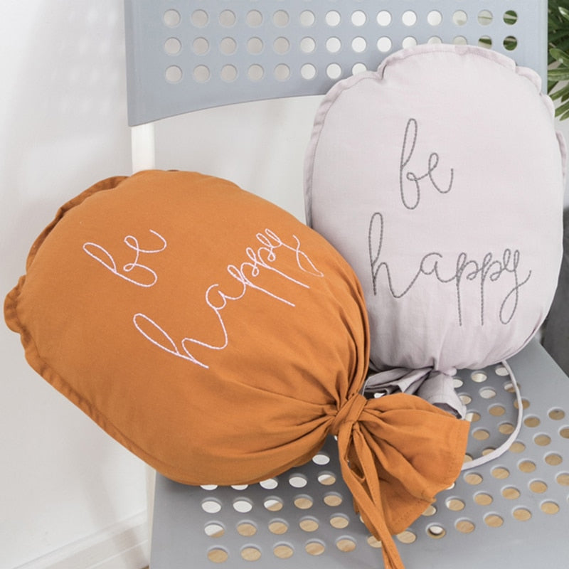 ballon mural bébé Be Happy rouille et gris sur une chaise