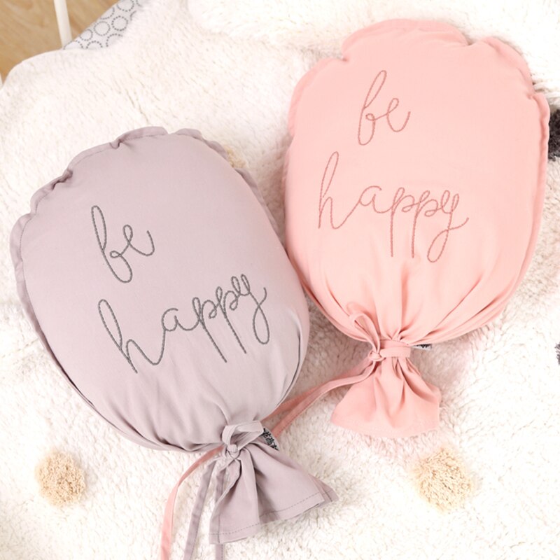 ballon mural bébé Be Happy gris et rose sur un tapis blanc