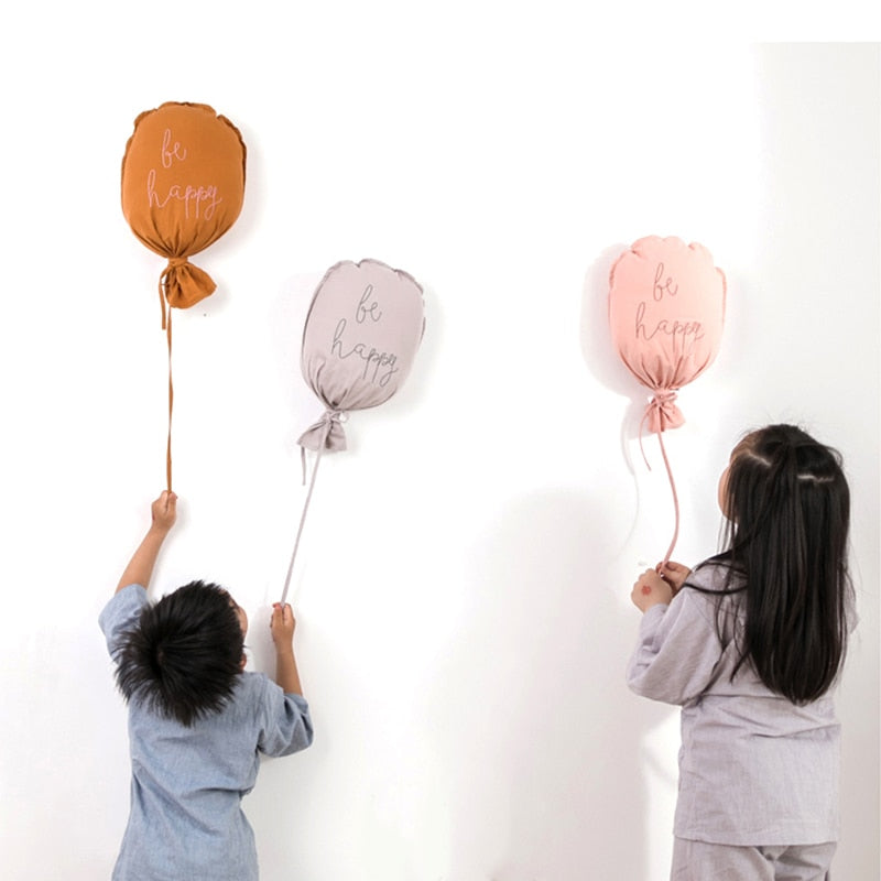 deux enfants de dos jouant avec le ballon mural Be Happy