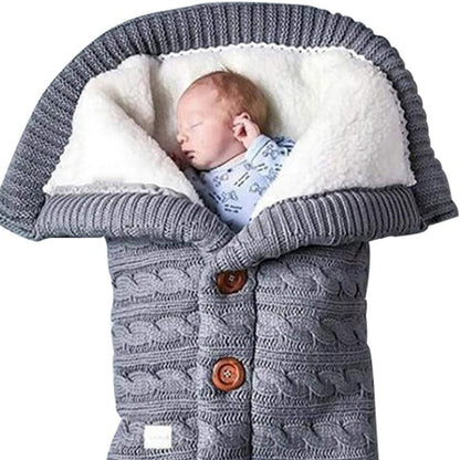Bébé dormant dans un nid d'ange effet tricot gris