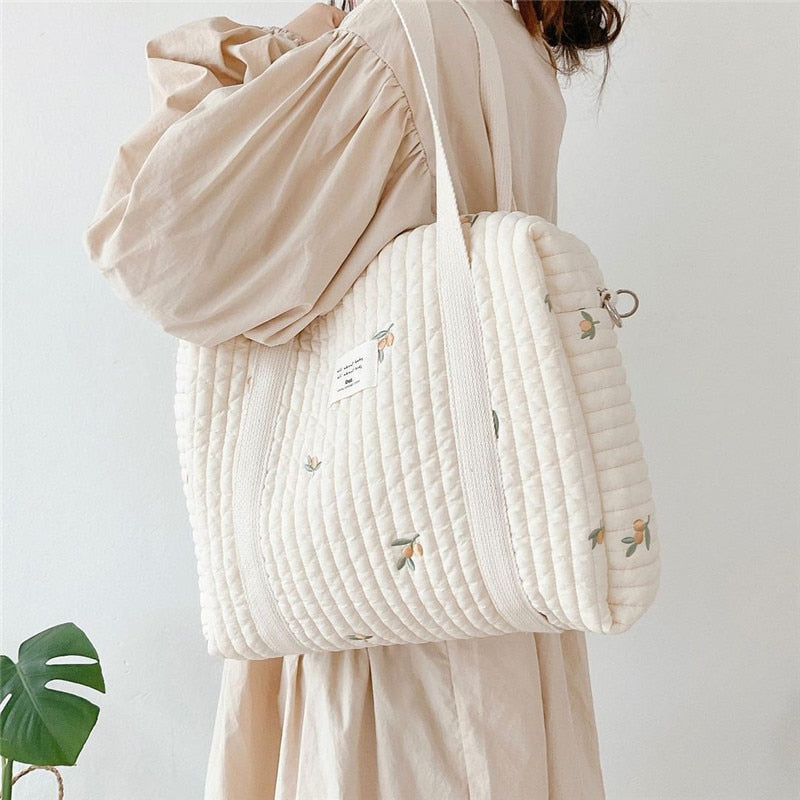 Femme portant sac à langer matelassé beige olives